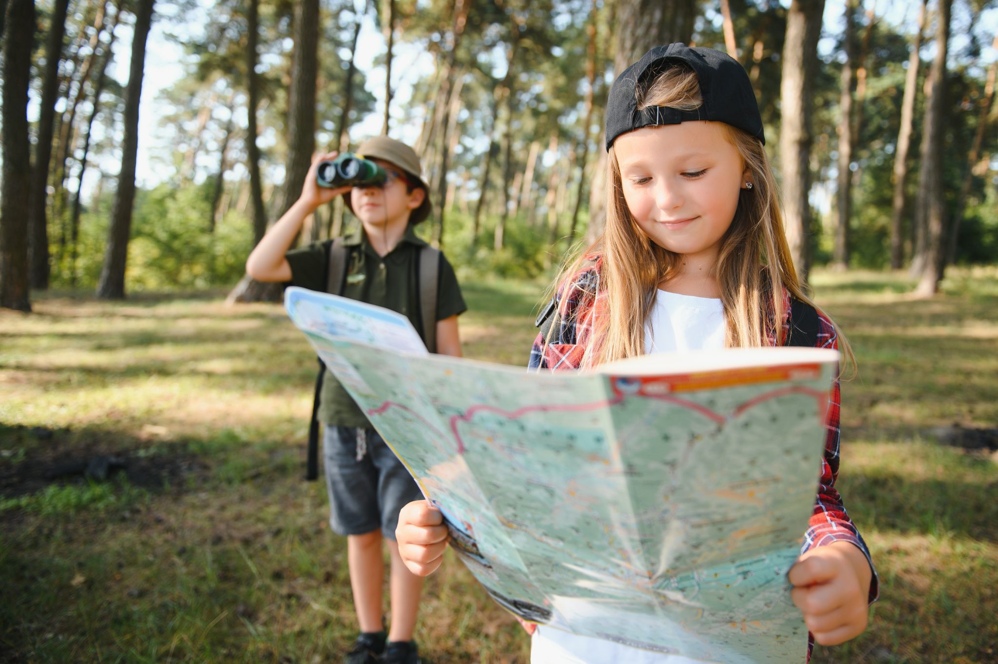 Little boy and girl go hiking on a forest road.