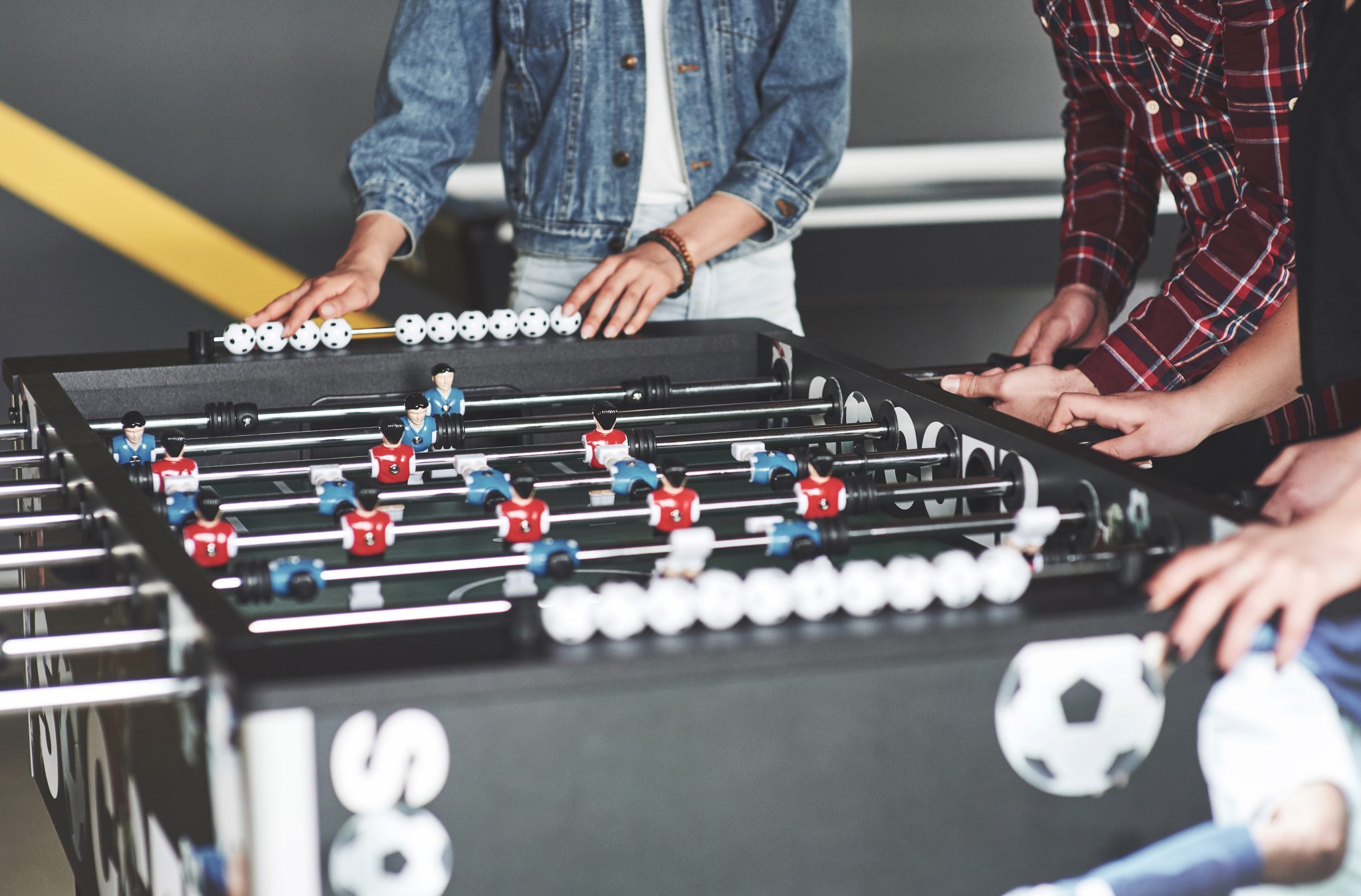 Smiling young people playing table football while on vacation.